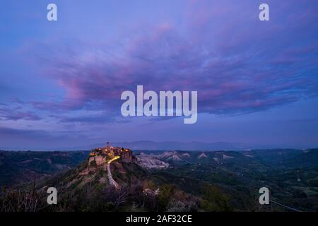 Civita di Bagnoregio, un ancien établissement étrusque, situé au sommet d'un plateau de tuf volcanique, illuminé de nuit après le coucher du soleil Banque D'Images