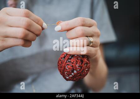 Libre d'une chaîne de liage femme à une boule de Noël rouge. Banque D'Images