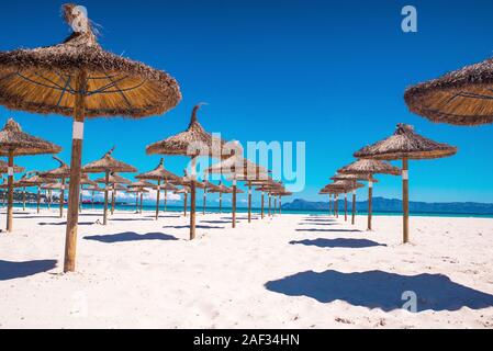 Transats et parasols de plage donnant sur les eaux bleu turquoise Banque D'Images