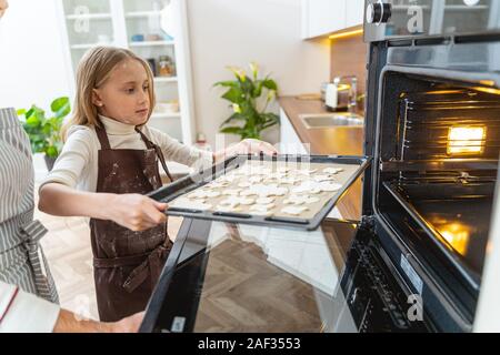 Young Caucasian dame tenant une feuille de biscuit Banque D'Images