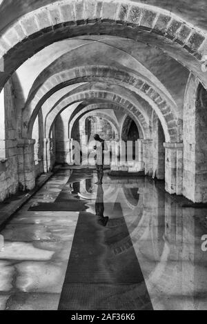 Son II par Antony Gormley; une sculpture d'un homme en contemplation tranquille dans la crypte partiellement inondée de la cathédrale de Winchester, Royaume-Uni Banque D'Images