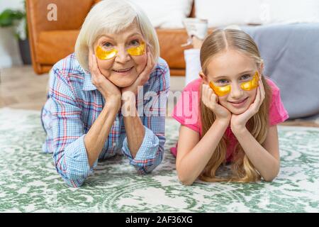 Jeune fille et sa grand-mère portant des électrodes oeil collagène Banque D'Images