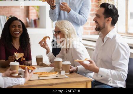 Collègues raciale Multi manger une pizza profitez de pause durant la journée de travail Banque D'Images