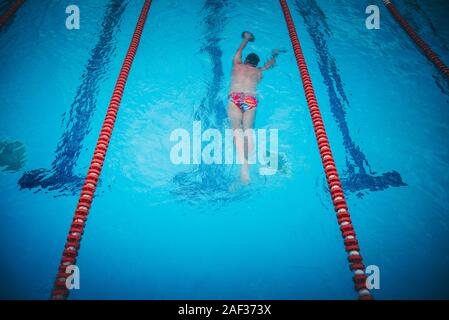 Jeune homme sportif natation en piscine durant la compétition freestyle Banque D'Images