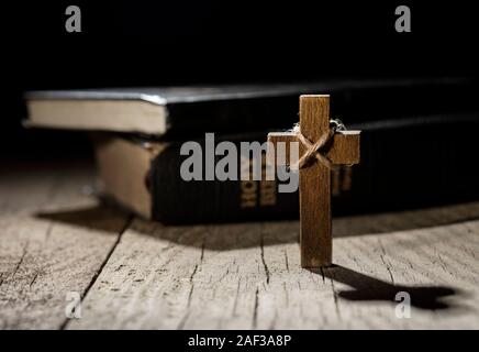 Croix de bois et la Sainte Bible sur table en bois sombre. Banque D'Images