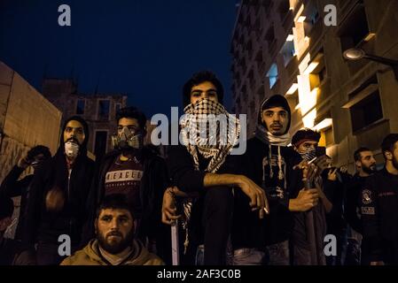 Les protestataires se tenir derrière la police, protégé par eux au cours d'affrontements dans le centre de Beyrouth comme les forces de sécurité de les séparer des partisans du parti Amal. D'artifice pierres et de cocktails Molotov ont été lancés sur des lignes de police par Amal partisans. La police a répondu par des gaz lacrymogènes sur un certain nombre d'heures. Beyrouth, 11 Dec 2019 Banque D'Images