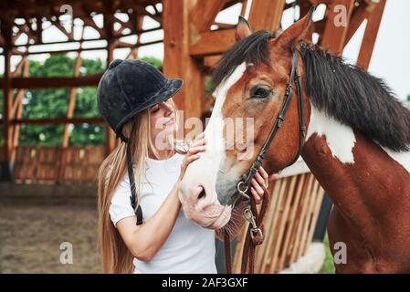 Caresser l'animal. Femme heureuse avec son cheval dans le ranch de la journée. Banque D'Images