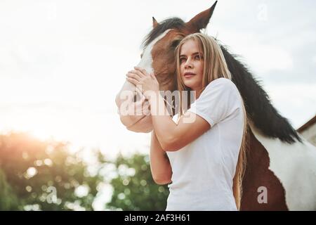 Sur le marche. Femme heureuse avec son cheval dans le ranch de la journée. Banque D'Images