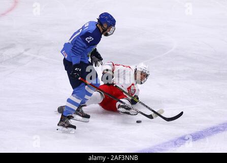 Kiev, UKRAINE - 12 décembre 2019 : Maximilien SOELVA d'Italie (L) lutte pour une rondelle avec Jakub LEWANDOWSKI de Pologne lors de leur championnat de hockey sur glace 2020 Banque D'Images