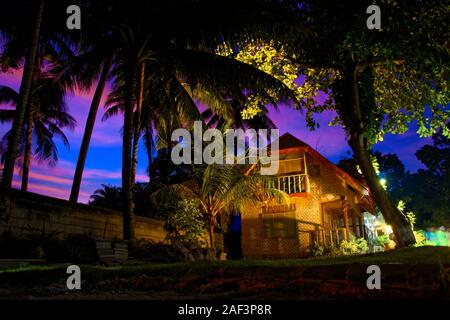 Bungalow avec vue incroyable coucher de soleil rose sur fond de l'île de Panglao, Philippines, résidence de vacances entouré de palmiers Banque D'Images