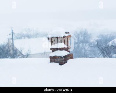 Une vieille cheminée de Kiripcha rouge sur un toit, tout est recouvert de neige, un paysage d'hiver Banque D'Images