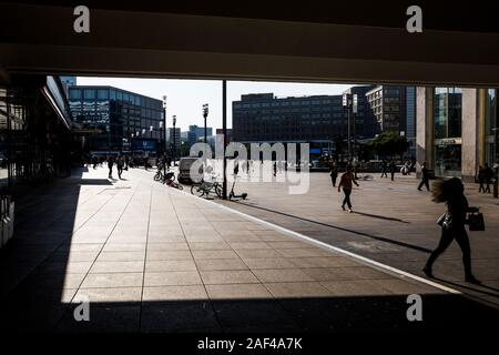 Les piétons qui se profile comme ils marchent à travers le matin Alexanderplatz à Berlin, Allemagne. Banque D'Images