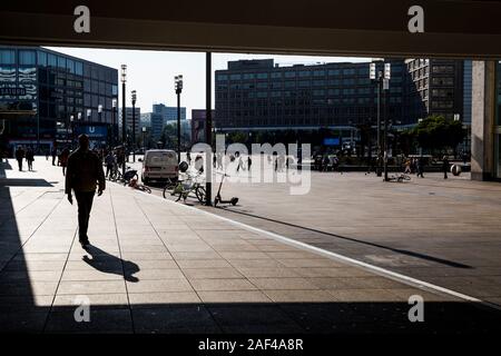 Les piétons qui se profile comme ils marchent à travers le matin Alexanderplatz à Berlin, Allemagne. Banque D'Images