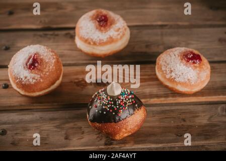 Round jelly donut sufganiyot et chocolat pour sufganiyah ou Hanoukka Hanoukka, fête juive sur un fond de bois. Vintage style. La tonalité de l'image. Banque D'Images