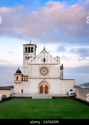 La majestueuse basilique de San Francesco à Assise, en Italie. Photographiée à l'aube, entre le brouillard du matin et le ciel nuageux sur une journée d'hiver. Banque D'Images