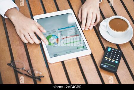 Gros plan des tablettes numériques dans les mains des femmes avec un concept de travail de tasse à café Banque D'Images