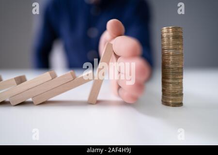 Close-up d'une main humaine l'arrêt des blocs de bois de tomber sur plus de 24 pièces empilées Banque D'Images