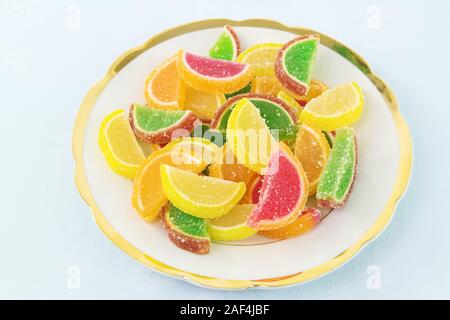 Plaque de gâteau blanc avec les bonbons de fruits multicolores sous forme de tranches d'agrumes Banque D'Images