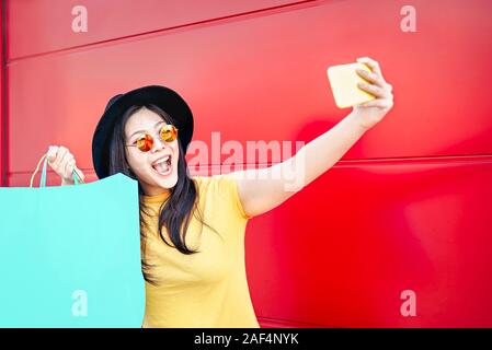 Happy Chinese girl making avec selfies mobile smartphone outdoor - influenceur social asiatique woman having fun doing shopping Banque D'Images