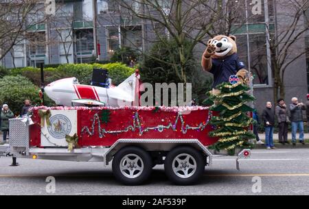 Vancouver, Canada - 1er décembre 2019 : un interprète en costume d'ours agise des gens de la plate-forme lors de la Parade annuelle du Père Noël à Vancouver Banque D'Images