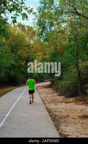 L'homme en chemise verte d'exécution sur sentier forestier Banque D'Images