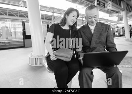 Mature Asian businessman et mature Asian woman explorer la ville ensemble Banque D'Images