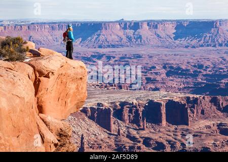 Une femme debout au bord du canyon en profitant de la vue spectaculaire. Island in the Sky, Canyonlands National Park, Utah, USA. Banque D'Images