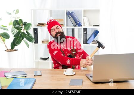 Le stress des fêtes. Homme très occupé a frappé un ordinateur portable avec un marteau. Obtenu le stress au travail. Le travail stressant. Soulagement du stress de Noël. Profitez des fêtes sans stress. Banque D'Images