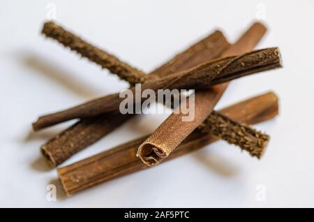 Les tripes de boeuf séché. Friandises pour chiens bois réparties au hasard sur un fond blanc. Close-up. Focus sélectif. Banque D'Images