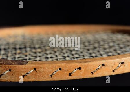 Close-up et les détails d'un vieux coup de raquette de tennis en bois en face de fond sombre Banque D'Images