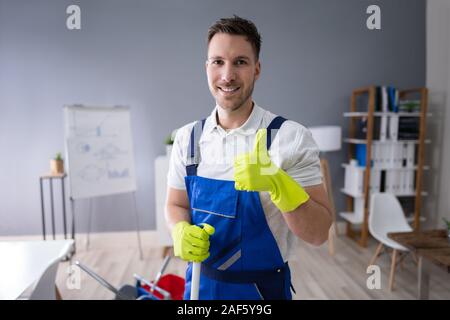 Portrait de Professionnels travailleur masculin avec bureau Nettoyage balai Banque D'Images