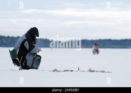 Frosty matin d'hiver la pêche sur la rivière. La pêche d'hiver. Vis de la glace près de Banque D'Images