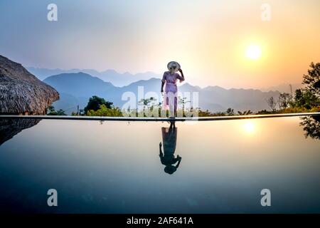 La commune de Pu Luong, province de Thanh Hoa, Vietnam - 1 octobre 2019 : Asian Woman in dress debout sur le bord d'une piscine à débordement et de la nature. Reso de luxe Banque D'Images