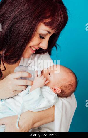 Maman, c'est de se nourrir le bébé du lait d'une bouteille Banque D'Images