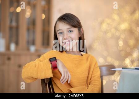 Cute girl en orange shirt smiling joliment Banque D'Images