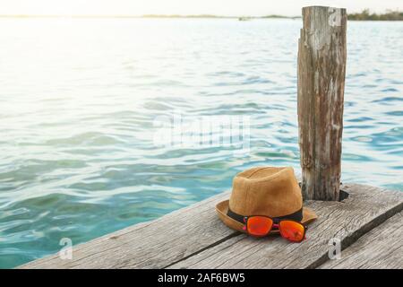 Chapeau de paille et lunettes de soleil sur la jetée en bois Banque D'Images