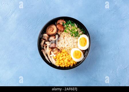 Soupe de nouilles ramen. Nouilles Soba avec des oeufs, shiitake et les champignons Enoki, le maïs sucré et les échalotes, top shot sur un fond d'ardoise Banque D'Images