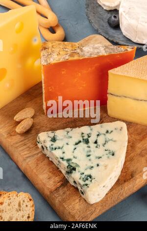 Plateau de fromages fromage bleu, rouge Leicester, Emmental, un gros plan sur une planche en bois Banque D'Images