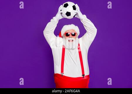 Photo de grey haired santa père holding football ball passer nouvel an nuit à regarder la finale de ligue de champion enthousiaste porter costume specs sun Banque D'Images