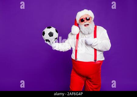 Photo de grey haired santa avec ballon de football en cuir de démonstration de nouveaux modèle football ball pour escompte x-mas : porter un costume specs sun Banque D'Images