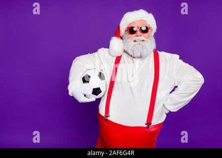 Photo de grey haired santa père holding football ball va dépenser newyear nuit à regarder l'usure caractéristiques techniques ligue de champion sun costume violet isolés Banque D'Images