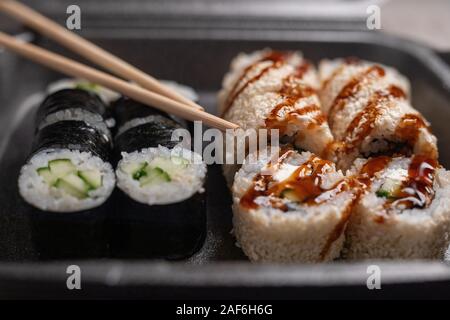 Ensemble de sushi assortis conservés dans un noir livraison fort, selective focus Banque D'Images