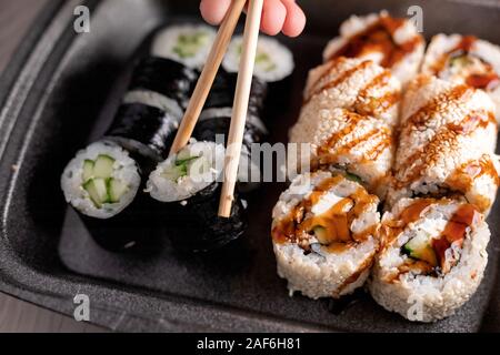 Rouleau de sushi au concombre, fromage à la crème, l'anguille et sauce unagi libre. Japon restaurant menu Mise au point sélective. Banque D'Images