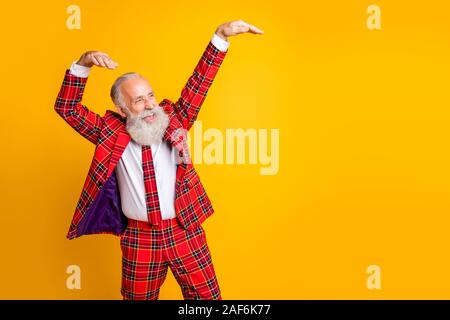 Photo de cool look grand-père avec barbe blanche au jeune danse partie étrange moderne se déplace à carreaux cravate blazer rouge porter vêtements jaune isolé Banque D'Images