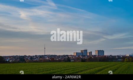 Allemagne, Tv tower building dans ville de Stuttgart derrière champ vert à côté de gratte-ciel à la lumière du soleil chaude soirée sur jour d'automne froid Banque D'Images