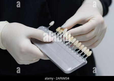 Le médecin tient dans sa main des tests pour les dents du patient avant le blanchiment Banque D'Images