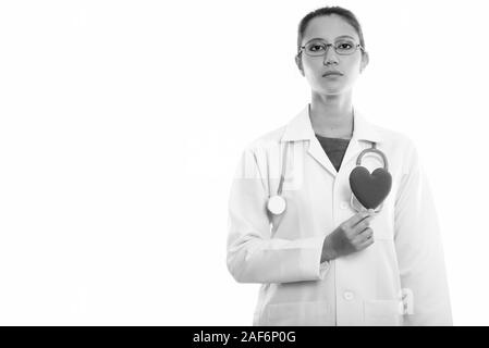 Studio shot of young Beautiful woman doctor holding red heart contre poitrine Banque D'Images