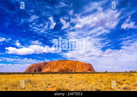 L'Uluru avec un intéressant la formation de nuages au-dessus au cours d'une journée ensoleillée. Banque D'Images