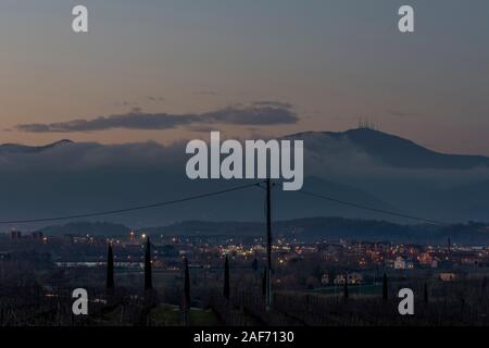 Pontedera et Monte Serra partiellement voilé dans le brouillard au coucher du soleil, Toscane, Italie Banque D'Images