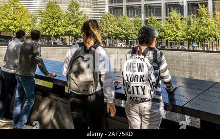 Un visiteur se tient à New York à la commémoration du 11 septembre 2 983 victimes des attentats terroristes du 11 septembre 2001. Leurs noms sont gravés sur la frontière de cuivre des deux grands bassins d'eau au Ground Zero. (18 Sept 2019) dans le monde entier d'utilisation | Banque D'Images